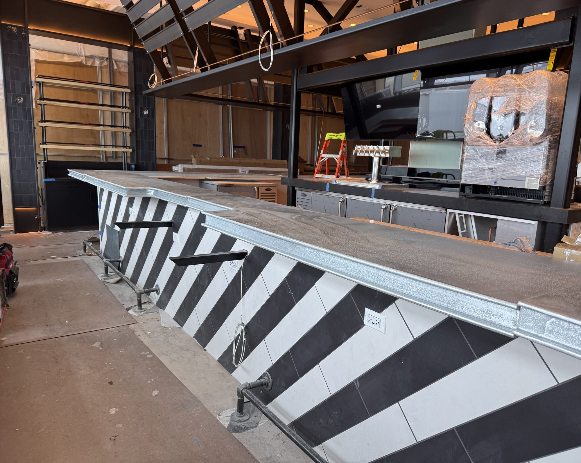 Chevron-tiled bar with new zinc top during install at Black Tap, JFK Terminal 8, New York