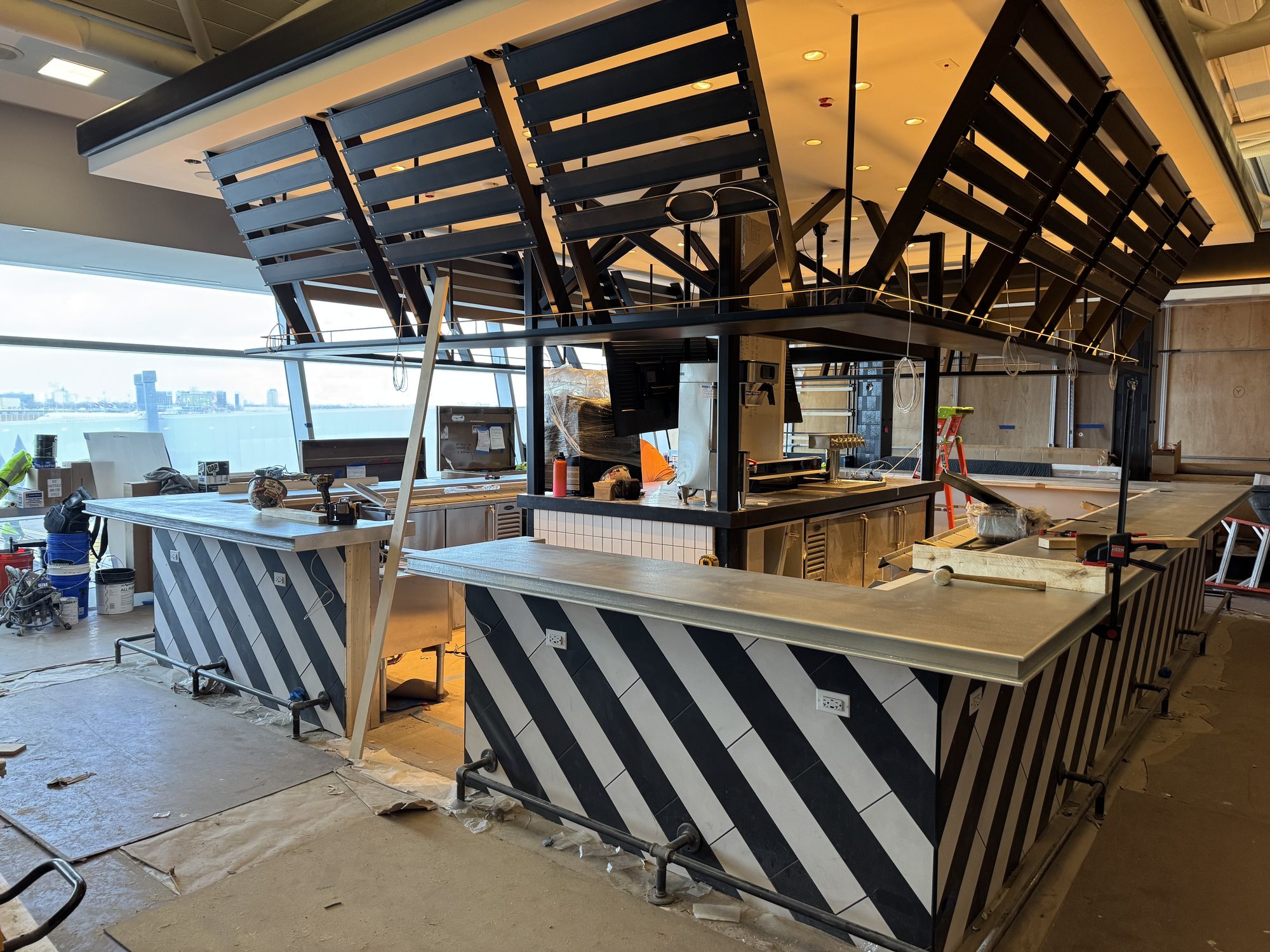 Zinc bar tops installed under the slatted canopy during construction at Black Tap, JFK Terminal 8, New York