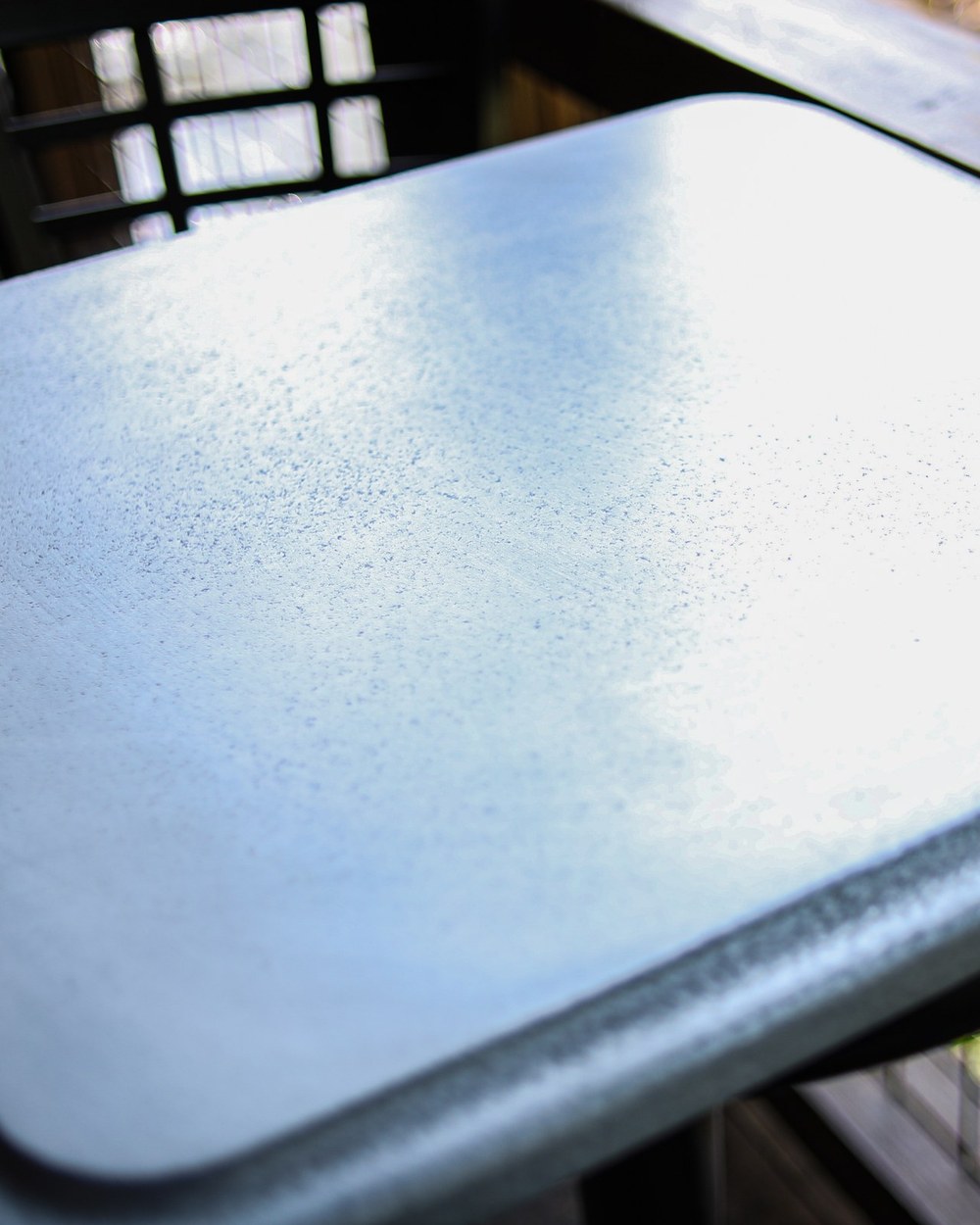 Close-up of a finished metal table top edge, installed outdoors