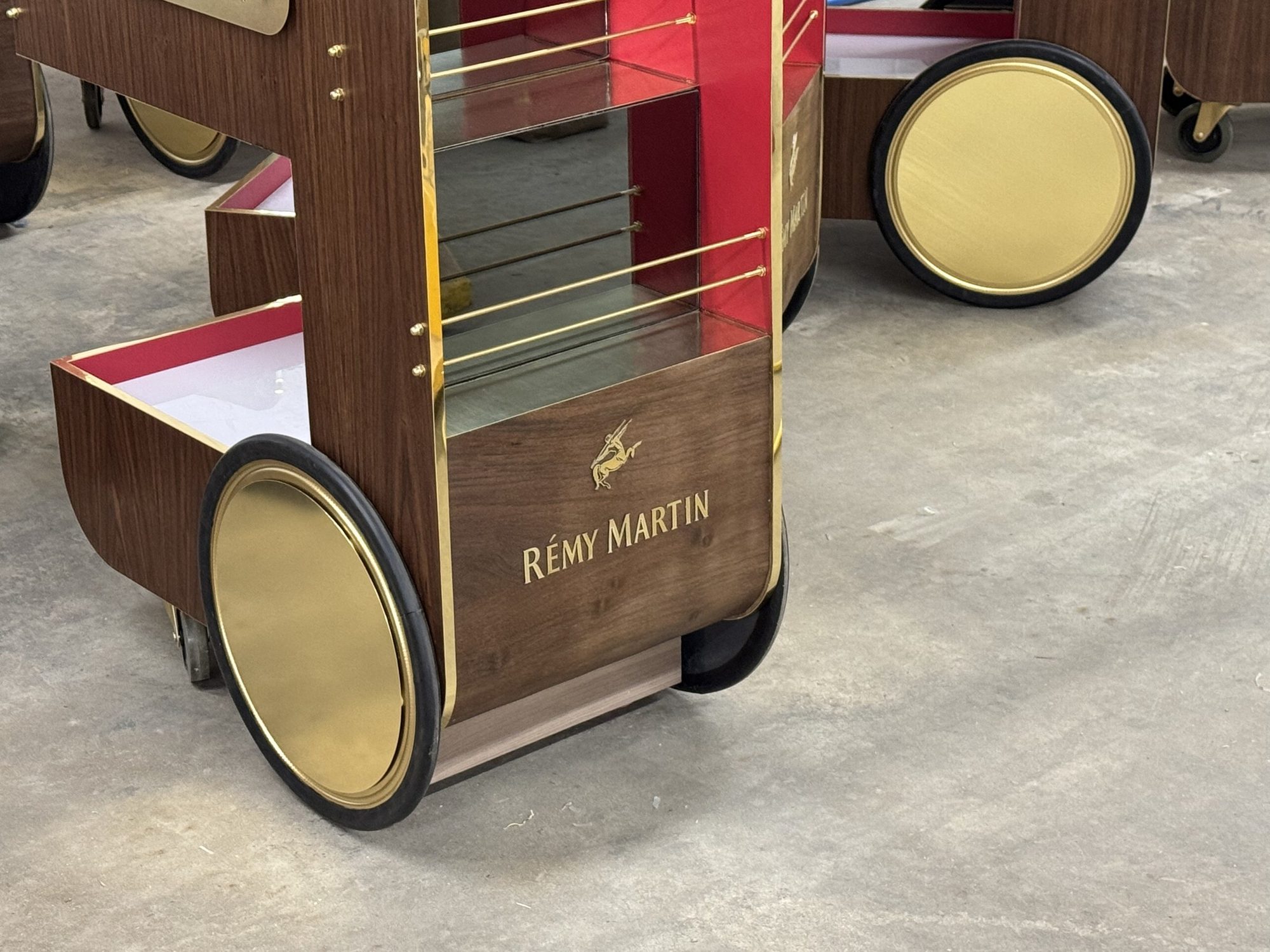 Brass-toned wheel cover and branded front panel on a Rémy Martin bar cart