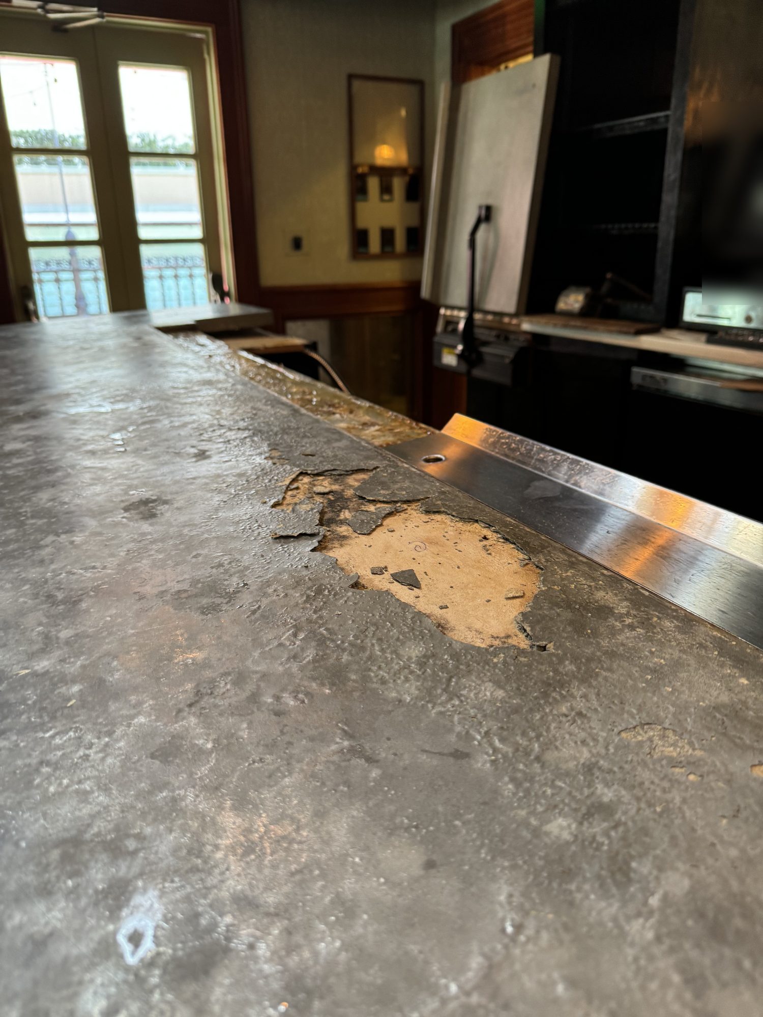 Old bar top lifting and flaking along the service side before replacement, Uptown Social, Charleston