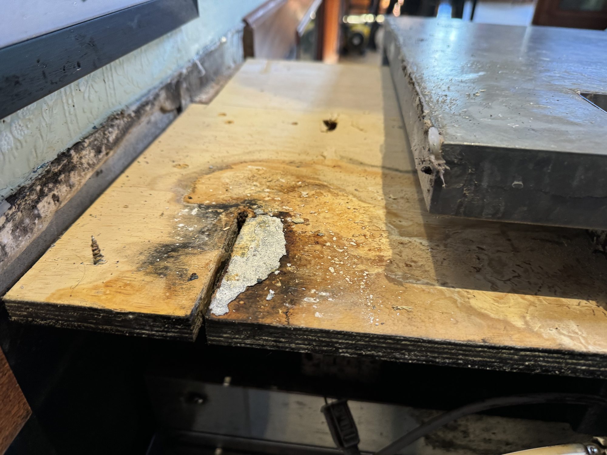 Water-damaged wooden core exposed under the old bar top, Uptown Social, Charleston